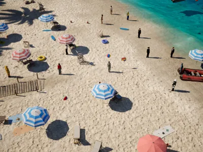 People and parasols along the water's edge, at the size they appear from the capture altitude